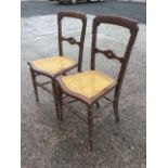 A pair of Victorian bedroom chairs, with quatrefoil pierced joining rails to backs above cane seats