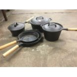 A set of four cast iron pans with wood handles; and a matching cast iron cooking pot & cover. (5)