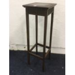 A square mahogany jardinere stand with fluted aprons, raised on column legs.