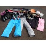 A quantity of skiing gear including a bag, ski suits, four pairs of ski boots, sticks, salopettes,