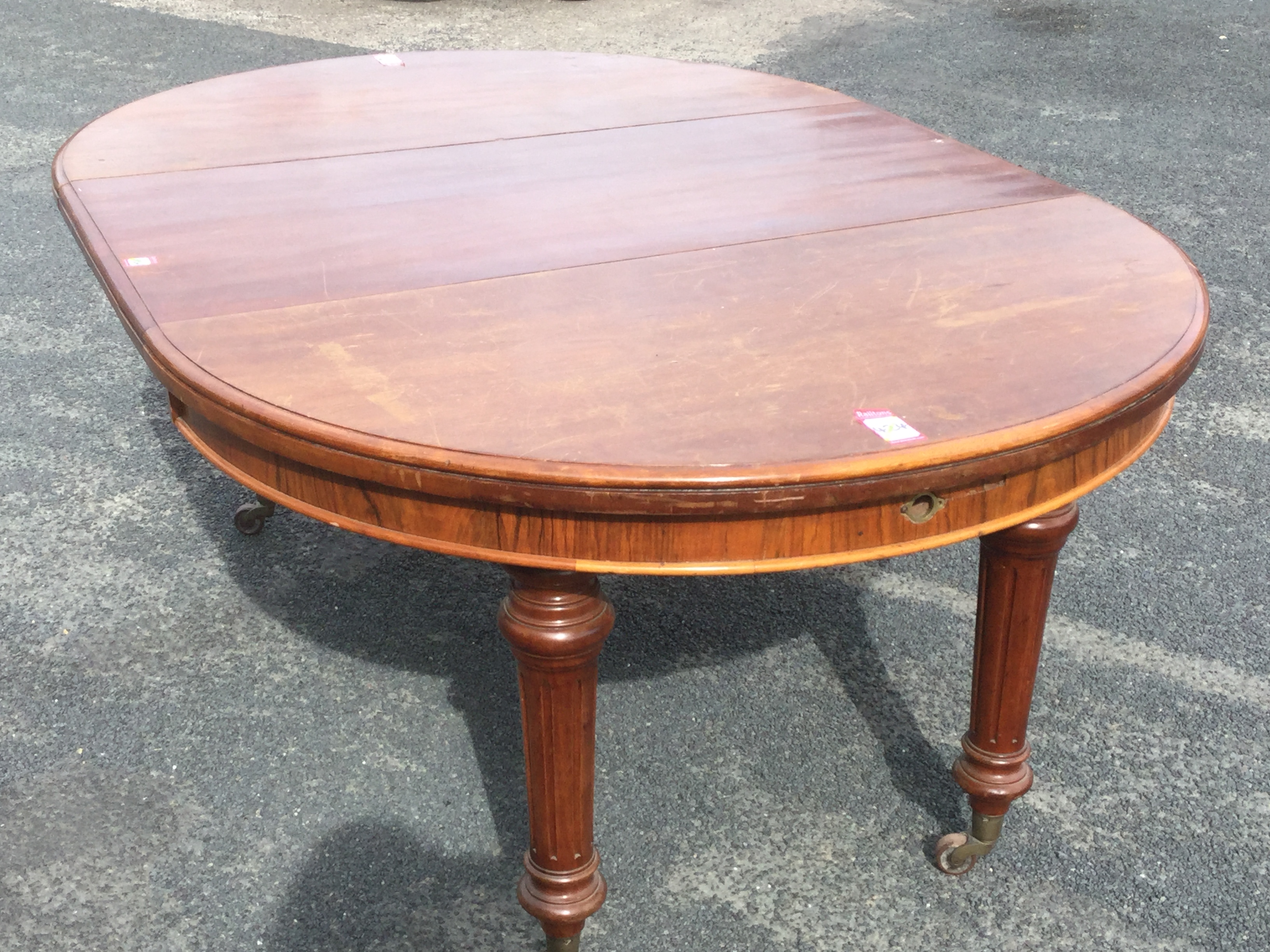 A Victorian walnut dining table with telescopic action and spare leaf