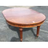 A Victorian walnut dining table with telescopic action and spare leaf