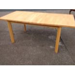 A beech draw-leaf dining table, the top with integral leaf, raised on angled rectangular legs.