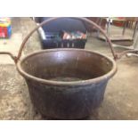 A large tubular copper cauldron with rolled rim, riveted with lugs to hold iron swing handle.