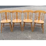 A set of four beech spindleback kitchen chairs, with solid seats raised on turned legs & stretchers