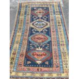 An antique oriental rug woven with four serrated medallions in blue field framed by borders