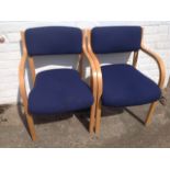 A pair of contemporary beech armchairs, with padded upholstered backs and downswept arms