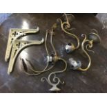 A pair of brass wall lights with scrolled branches holding light fittings, and another very similar;