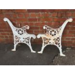 A pair of cast iron bench ends, with scrolled arms and circular pierced roundels