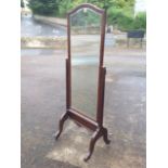 A stained cheval mirror, the bevelled plate in arched moulded frame supported on columns,