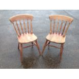 A pair of beech spindleback kitchen chairs, with solid seats raised on turned legs & stretchers. (2)