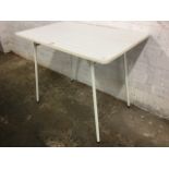 A formica topped kitchen table raised on tubular metal frame with angled legs.