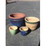 A terracotta blue glazed pot with moulded band- holed; and three glazed stoneware pots. (4)