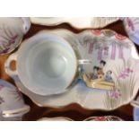 A Japanese tea set with cups on integral saucers, each piece decorated with geisha girls in a boat