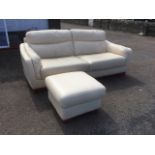 A cream leather sofa with panelled cushions raised on block feet