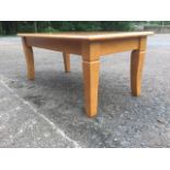 A rectangular hardwood coffee table, the moulded top on square sabre legs.