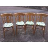 A set of four beech fiddleback kitchen chairs with solid seats raised on turned legs, fitted with