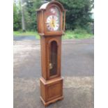 A Jaycee reproduction oak longcase clock, the arched hood supported by turned columns