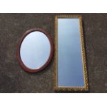 A rectangular mirror in pierced scrolled gilt frame; and an oval framed mirror. (2)