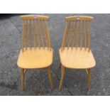 A pair of beech spindleback kitchen chairs, with shaped seats raised on turned legs & stretchers