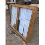 A hardwood noticeboard, the case with two glazed doors and baize lining.