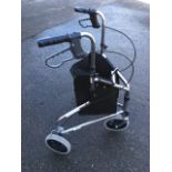 A three wheel mobility aid with tubular frame, rear brakes and shopping basket.