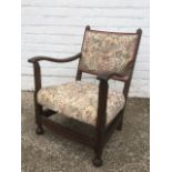 An oak armchair, with upholstered back & shaped arms