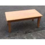 A rectangular hardwood coffee table, the moulded top on square sabre legs.