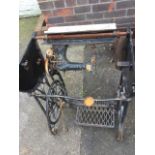 A Vesta sewing machine on cast iron treadle stand with casters.