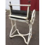 A Ewbank mangle with wood rollers in sprung press, the angle iron frame on casters.