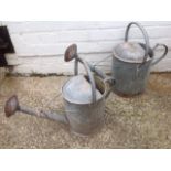 A matched pair of graduated galvanised watering cans, two & three gallon capacities, both with