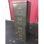 A four drawer metal filing cabinet with tubular brass handles and file label holders.