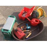 A dog basket; a gardening stool and various garden tools; a garden hose reel; and a toolbox