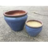 A graduated pair of blue glazed stoneware garden pots