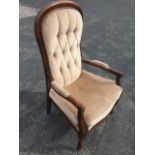 A Victorian style armchair, with studded button upholstered arched back