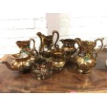 A collection of floral polychrome decorated Victorian copper lustre jugs