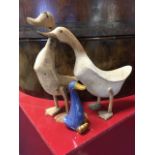 Two decorative carved hardwood ducks; and a ceramic glazed stoneware duck. (3)