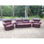 A burgundy leather three-piece suite