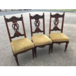 A set of three late Victorian carved walnut dining chairs