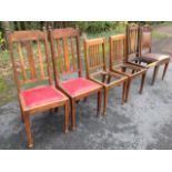A pair of late Victorian oak dining chairs with slat backs and studded upholstered seats