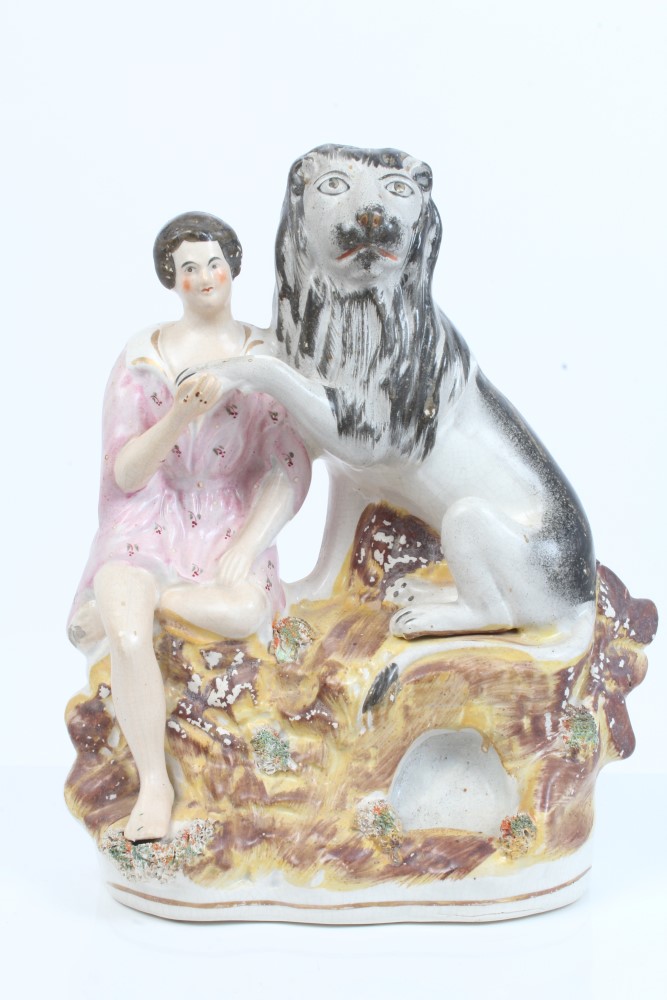 Victorian Staffordshire figure of Daniel holding the paw of a lion, on rocky base,