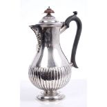 Edwardian silver hot water jug of baluster form, with half-fluted decoration, foliate spout,