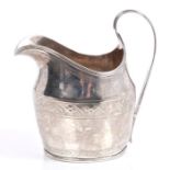 George III Irish silver cream jug of helmet form, with bright cut decoration,