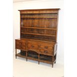 Early 19th century oak high dresser, the boarded rack with stepped cornice,