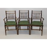 Set of three early 20th century turned beech and rush seated country spindle back elbow chairs in