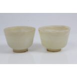 Pair of carved Chinese jade cups of slightly tapered form, on squat foot, 5.