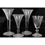 Two Georgian wine glasses with drawn funnel bowls and plain stems - one on folded foot and two