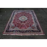 Good quality meshed carpet with allover floral design on brick red ground within multiple meander