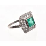 Emerald and diamond cluster ring, the rectangular step cut emerald weighing 1.