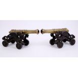 Good pair of brass signalling cannons each raised on cast iron wheeled carriage with dragon